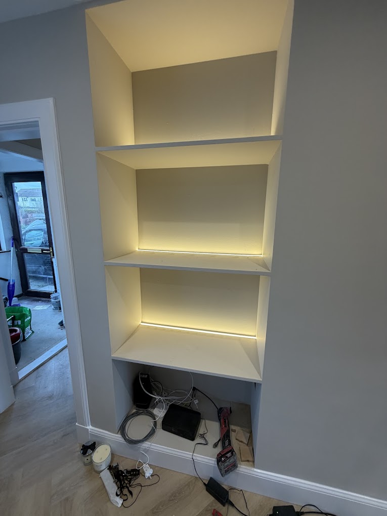 Built-in alcove shelving with warm LED strip lighting